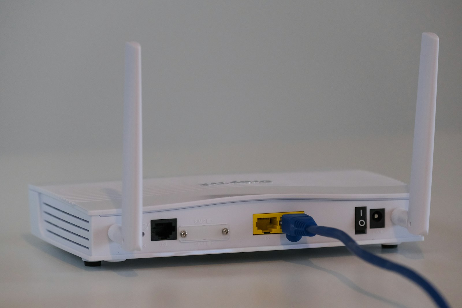Белый Wi-Fi роутер с антеннами и подключёнными кабелями — рейтинг mesh-систем 2026