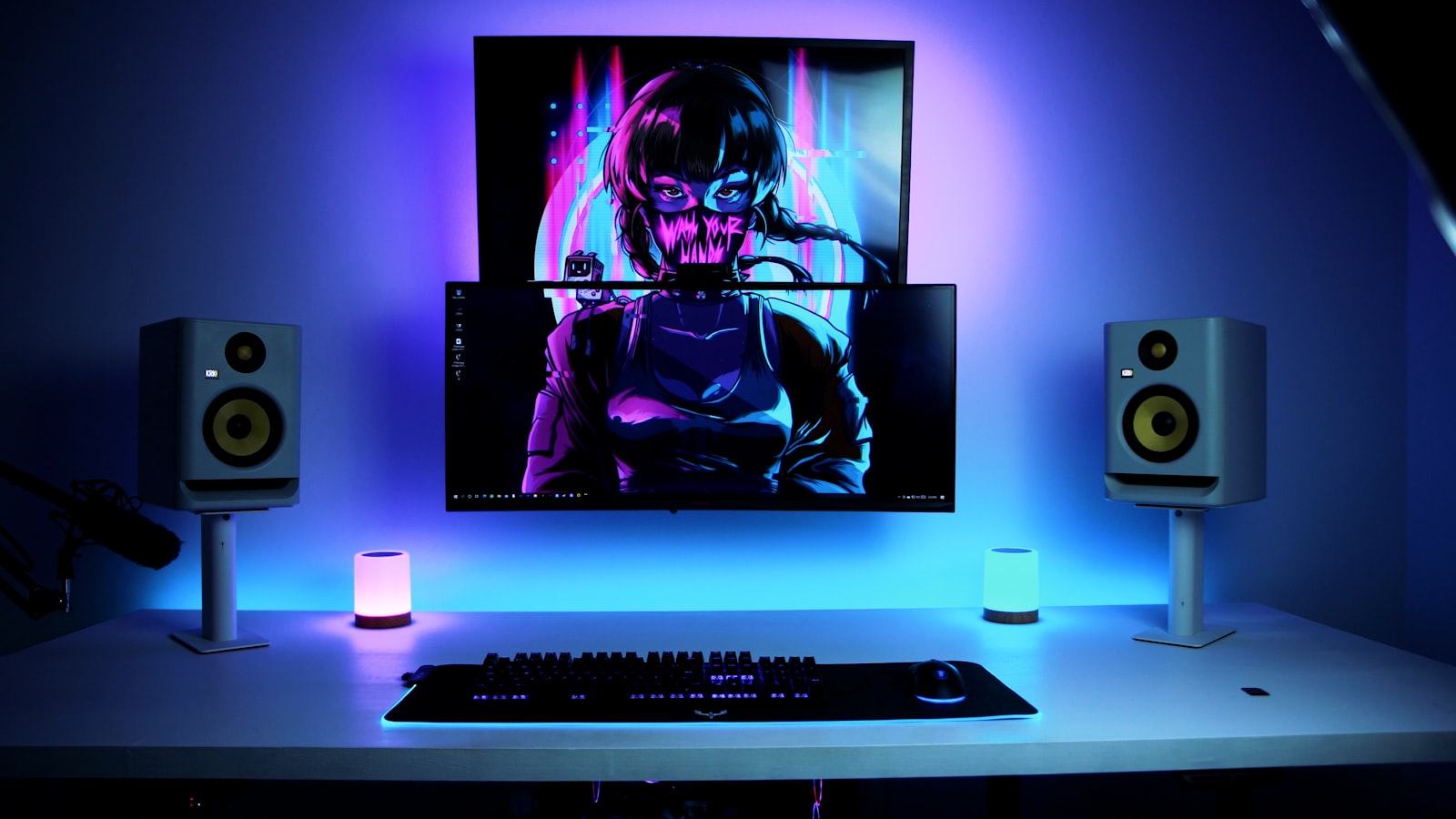Игровой стол с монитором, колонками и RGB-подсветкой в сине-фиолетовых тонах