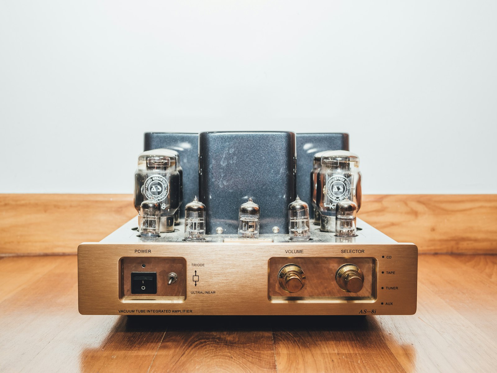 Интегрированный hi-fi усилитель с CD-входом, регулятором громкости и входными селектором на деревянном столе