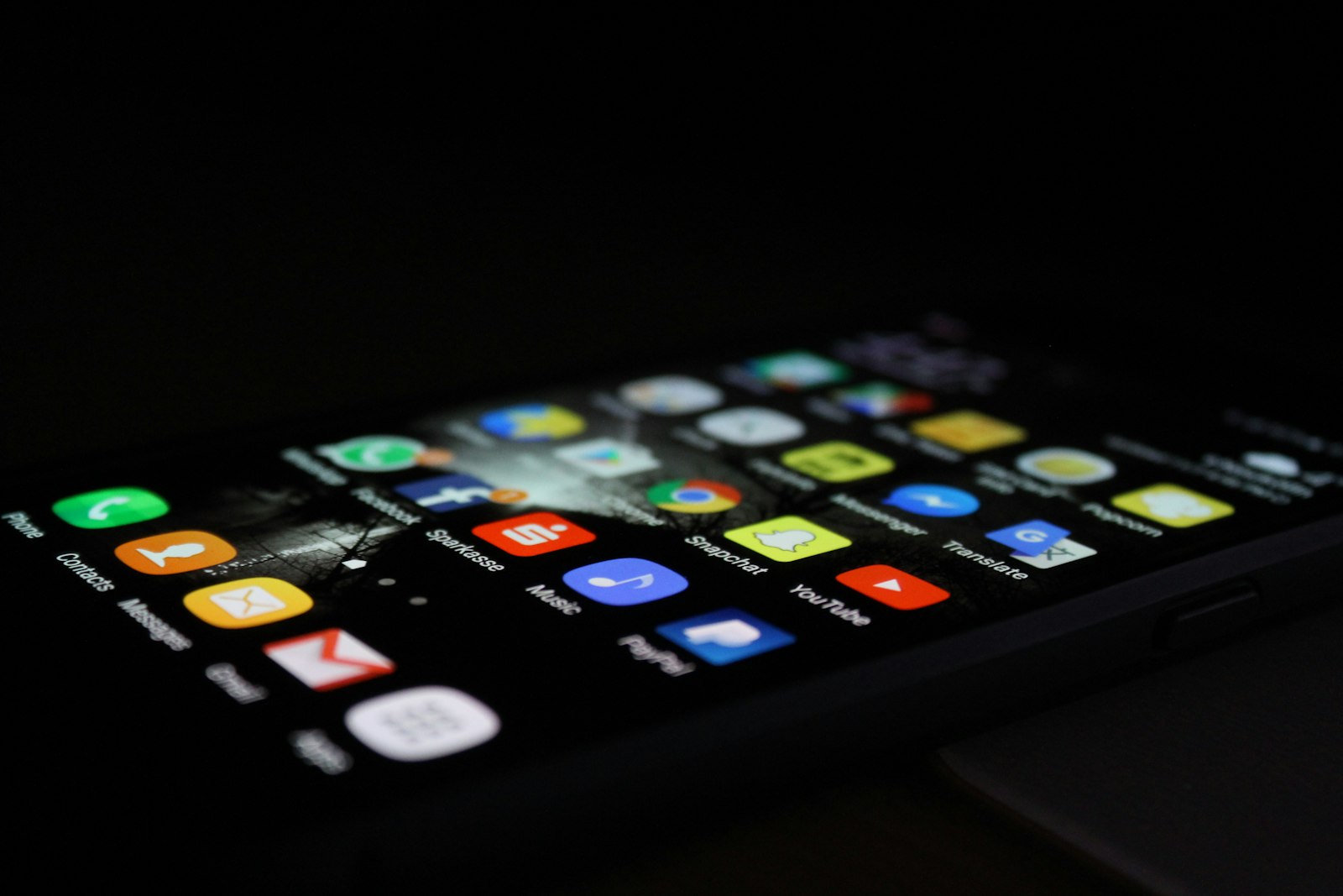 Android-смартфон с изогнутым экраном и сеткой приложений светится в темноте