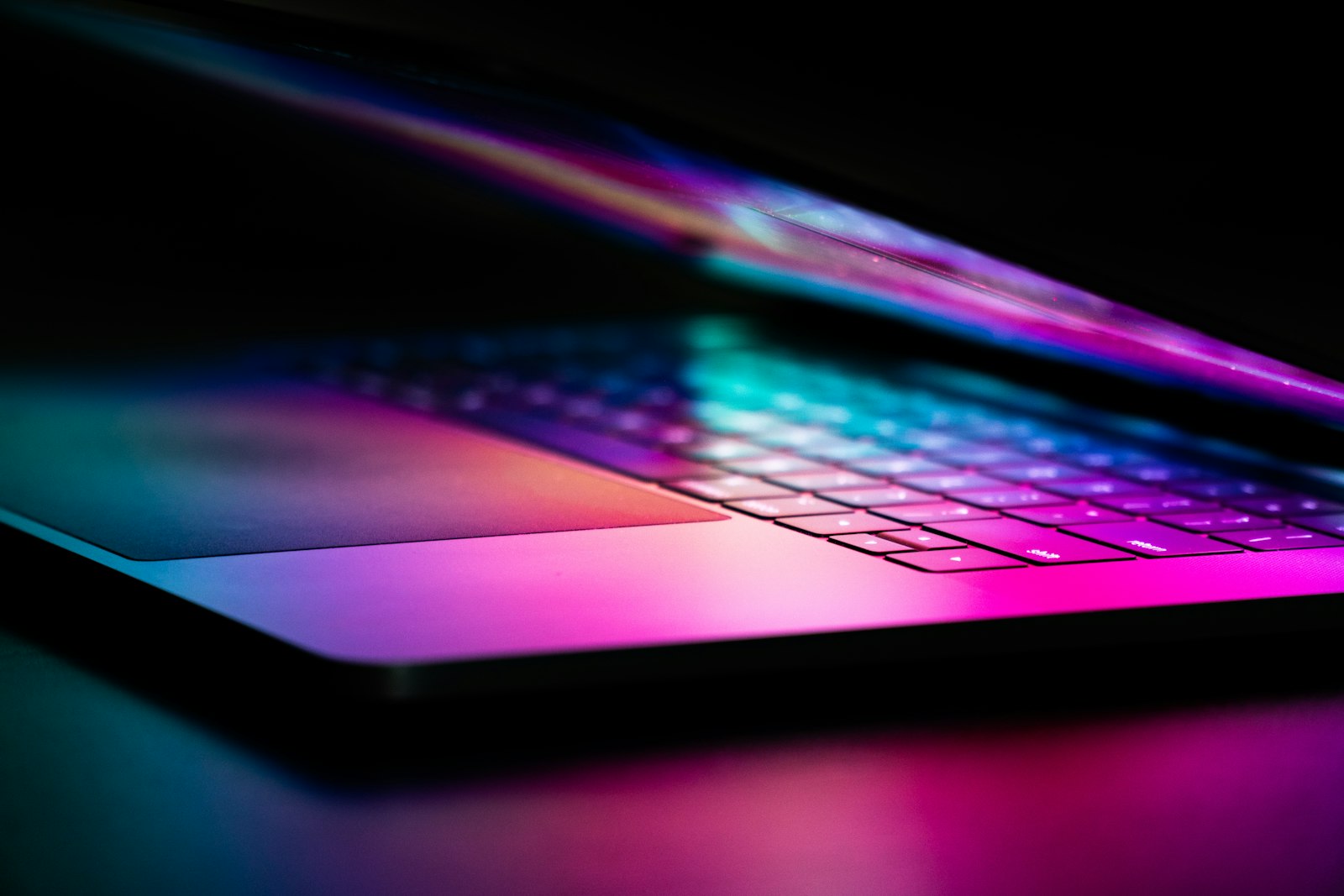 Игровой ноутбук с многоцветной RGB-подсветкой крупным планом на тёмном фоне