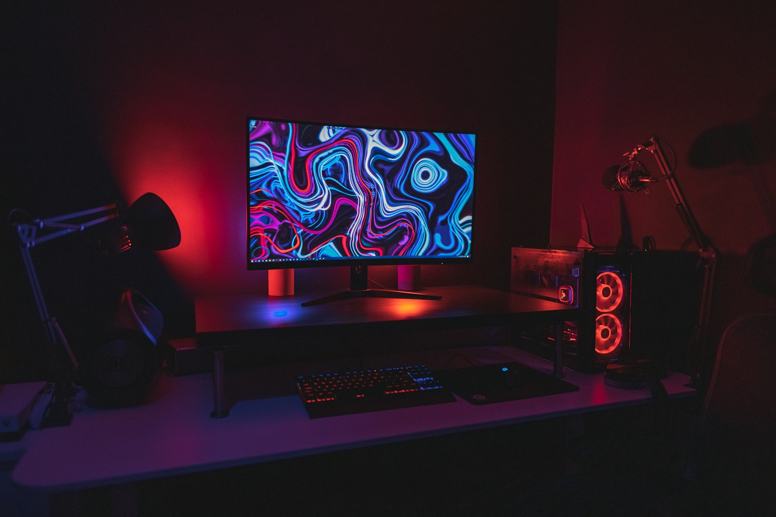 Тёмный игровой стол с изогнутым монитором с RGB-подсветкой и механической клавиатурой
