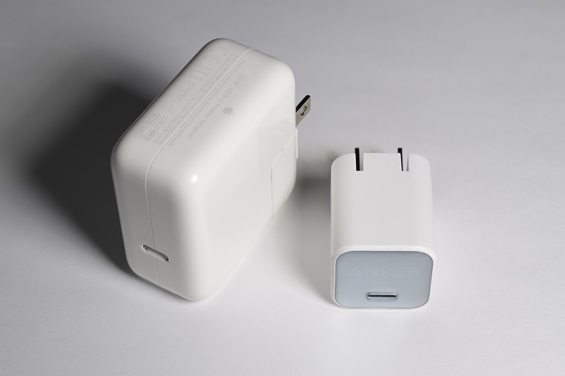 Компактная GaN-зарядка рядом с более крупным обычным USB-C адаптером