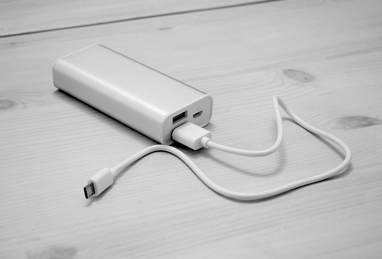 Компактный power bank с USB-кабелем на деревянной поверхности